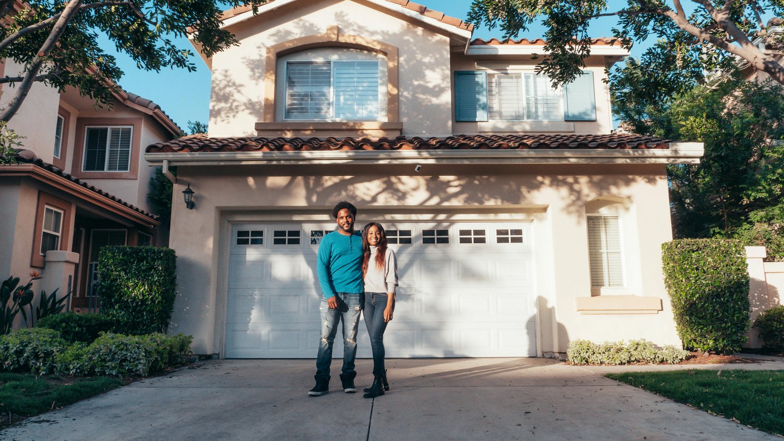 A couple standing outside the home they are selling