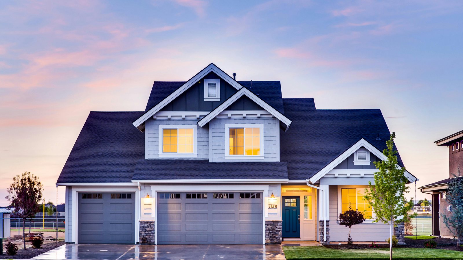 A family home at dusk with the lights on
